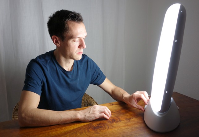 Homme utilisant une lampe de lumière du jour contre la dépression hivernale